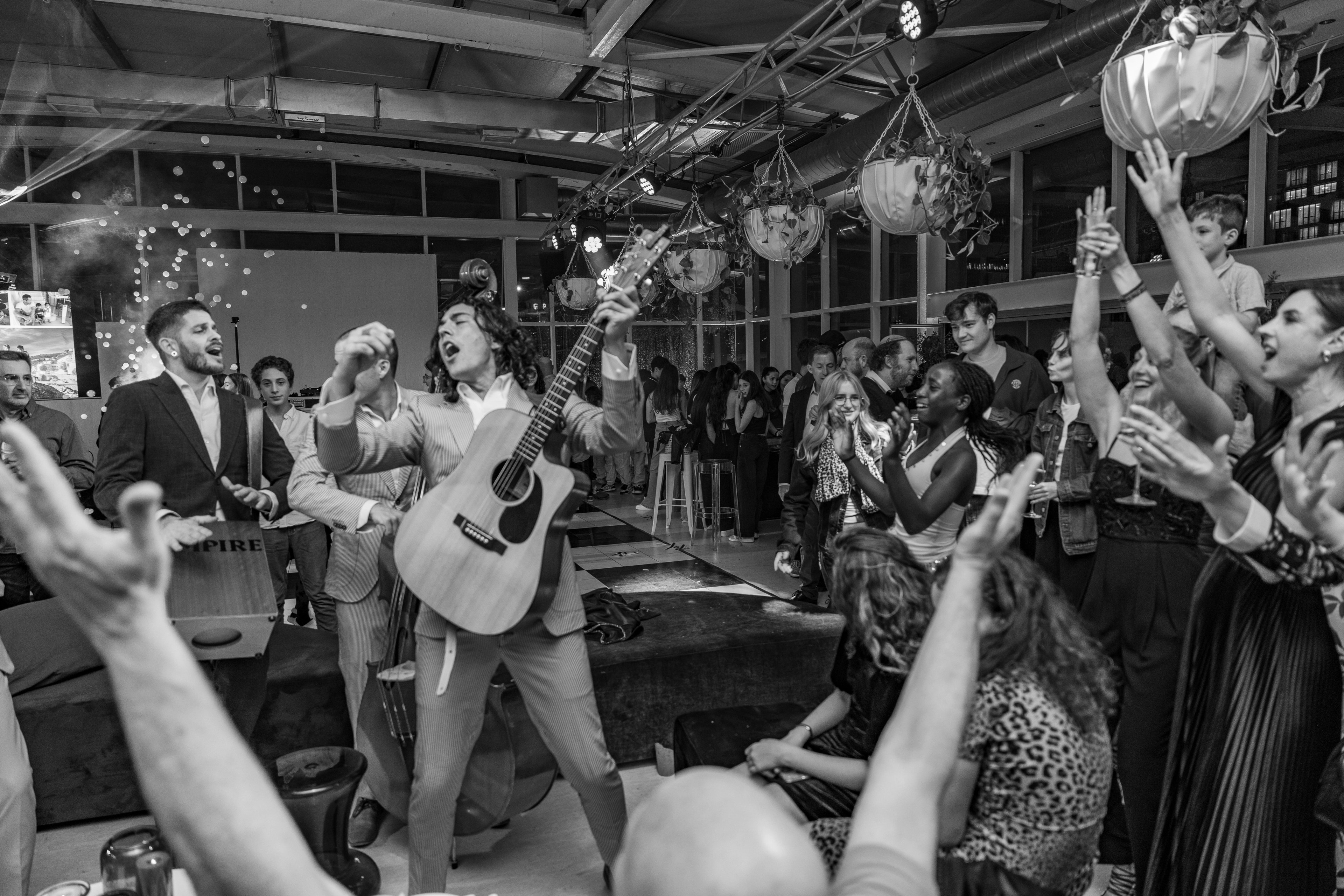 An Empire guitarist leading a guest singalong in black and white