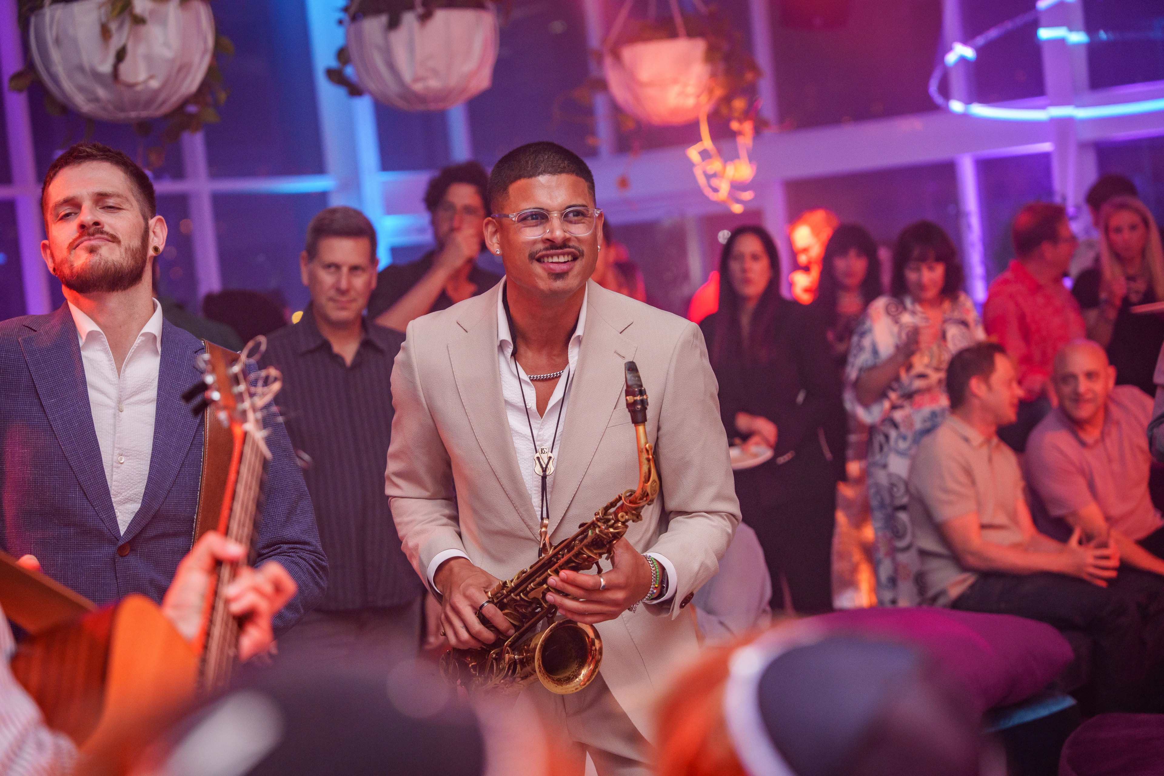Empire's saxophonist performing among guests during a late-night venue set
